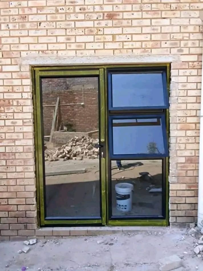 Aluminium top-hung window and door frame fitted into brickwork