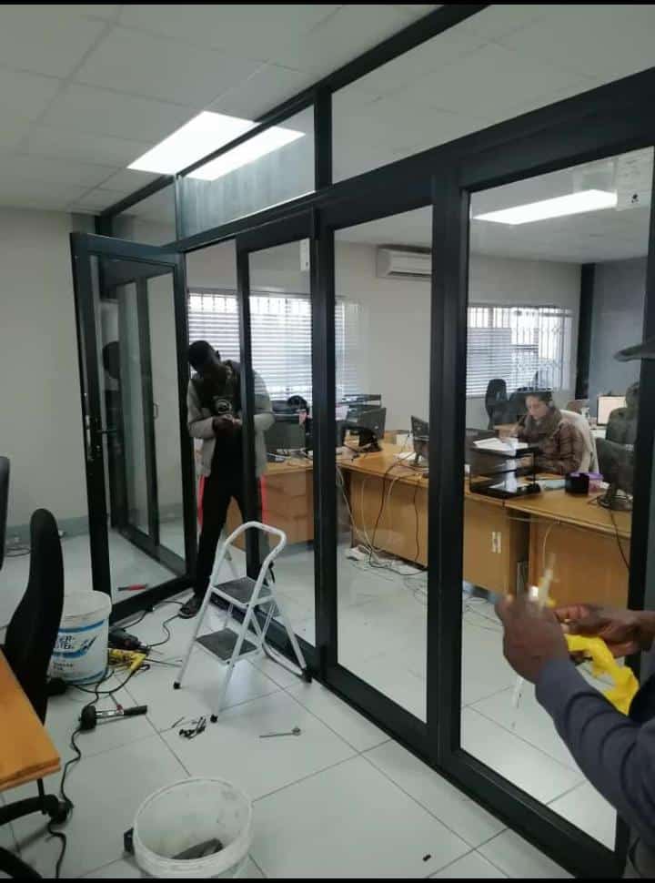 Team installing aluminium and glass office partitioning